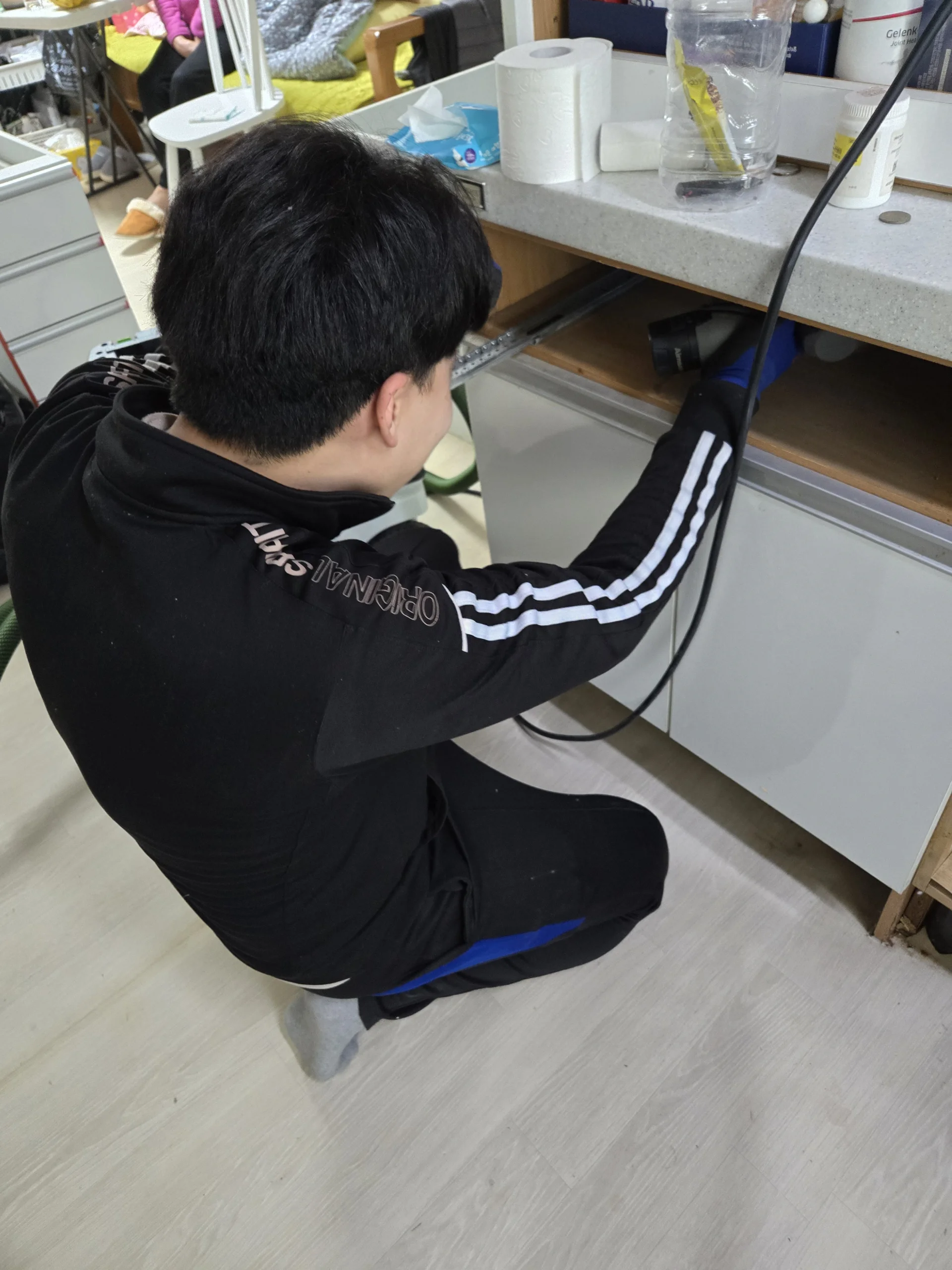 싱크대 수리 현장실습 쪼그려 앉아 하부장 안쪽을 점검하는 실습 실제 수강 사진